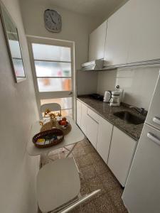 Una pequeña cocina con una mesa y un fregadero. en Departamento FABULOSO en 25 de mayo, en Santa Fe