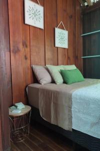 a bed in a room with wood paneled walls at Aventura Familiar Bosque Tropical Volcán Arenal in San Ramón