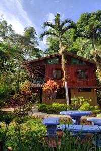 a house with picnic tables in front of it at Aventura Familiar Bosque Tropical Volcán Arenal in San Ramón