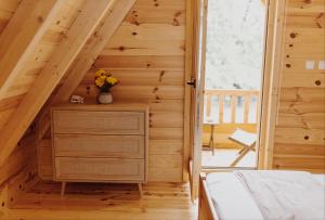 a bedroom in a log cabin with a bed and a window at Brvnara Mila Vinci in Golubac