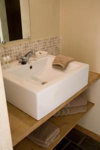 een badkamer met een witte wastafel en een spiegel bij B&B Hoeve de Steenoven in Damme