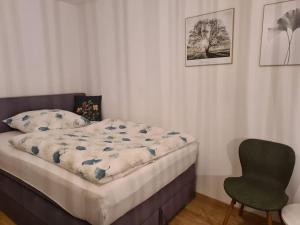 a small bedroom with a bed and a chair at Schöne Appartement-Wohnung in Frixheim