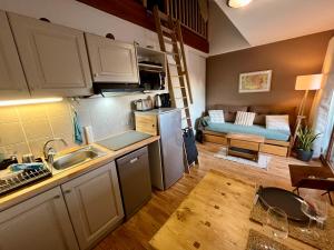 a small kitchen and living room with a couch at Orcières Merlette - Haut Champsaur, classé 3* in Orcières
