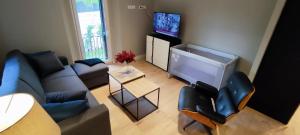 a living room with a couch and a flat screen tv at La Casita de Chloe in Escorial