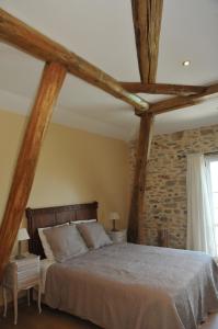 1 dormitorio con 1 cama grande con vigas de madera en Maison Matisse, en Saint-Nazaire-dʼAude