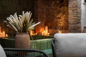 Una mesa con un jarrón con velas y una silla. en Casa Azalia - Marbella Old Town, en Marbella