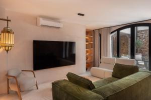 Una sala de estar con un sofá y un televisor de pantalla plana. en Casa Azalia - Marbella Old Town, en Marbella