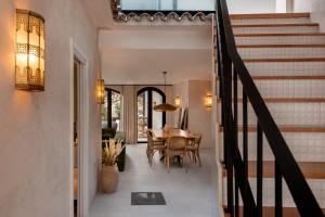 Un comedor y una cocina con mesa y escaleras. en Casa Azalia - Marbella Old Town, en Marbella