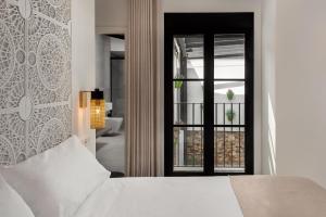 Un dormitorio con una cama blanca y una ventana. en Casa Azalia - Marbella Old Town, en Marbella 34 fotos más