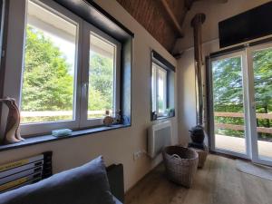 - un salon avec trois fenêtres et un canapé dans l'établissement Petite maison vue sur Lac de la Triouzoune Neuvic, à Neuvic