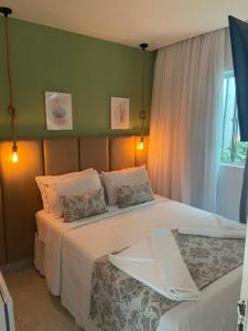 马拉戈日Pousada LuMar Maragogi的一间卧室设有两张带白色床单的床和窗户。