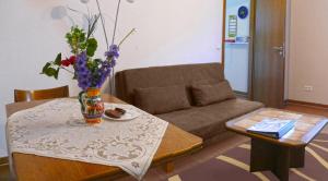 a living room with a couch and a table with a vase of flowers at Himmelbett-Ferienwohnung Oberwesel in Oberwesel