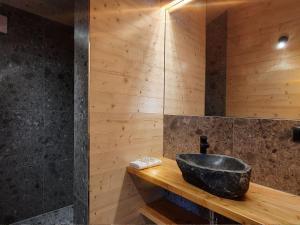 a bathroom with a stone sink on a wooden counter at Werder Chalet -- WOLKE 7 -- Ostsee-Strand 150m I Sauna I eKamin I Tiny House für 2 Personen I by "Meyers am Meer" in Boiensdorf