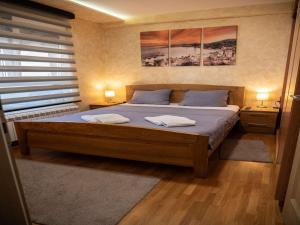 a bedroom with a large bed with two towels on it at Apartman DND Zlatibor sa garažom in Zlatibor