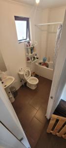 a bathroom with two toilets and a sink and a tub at Depto doble cerca del Centro in Talca +3 photos