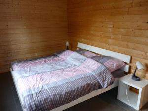 Un dormitorio con una cama con una pared de madera. en Holiday home family Junk, en Waldorf 10 fotos más