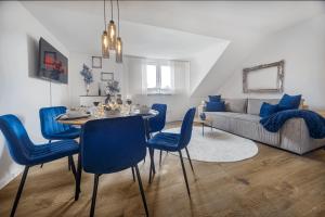 ein Wohnzimmer mit einem Tisch und blauen Stühlen in der Unterkunft Exquisite Superior Suite 80m2 mit 2 Schlafzimmern & Badewanne - Messe Essen in Essen