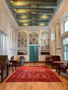 a living room with a rug on the floor and a blue door at Usman Heritage in Bukhara