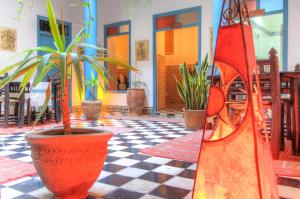 una habitación con macetas en un suelo a cuadros en Les Matins Bleus, en Essaouira