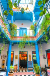 a building with blue columns and plants in a building at Les Matins Bleus in Essaouira