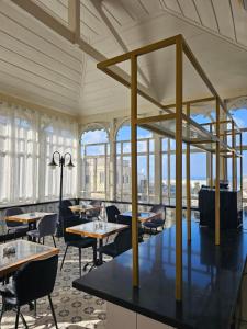 ハイファにあるCohen's Boutique Hotelのテーブルと椅子と窓のあるレストラン