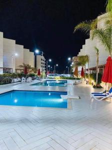 a swimming pool at a resort at night at بورتو سعيد in `Ezbet Shalabi el-Rûdi