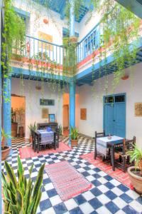 une cour avec des tables et des bancs dans un bâtiment dans l'établissement Les Matins Bleus, à Essaouira