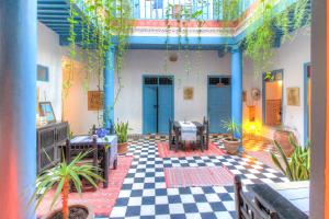 a patio with a checkered floor and blue doors at Les Matins Bleus in Essaouira