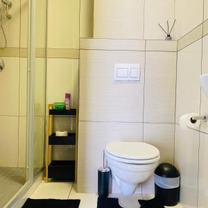 a bathroom with a white toilet and a shower at Comfy Corner Windhoek in Windhoek +17 photos