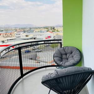 a balcony with a chair and a view of a parking lot at Comfy Corner Windhoek in Windhoek