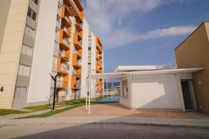 a building with a garage next to two tall buildings at Penthouse en Pitalito in Pitalito