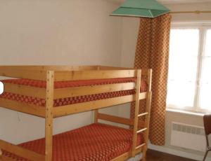a bunk bed in a room with a window at Maison T3 avec jardin centre-ville in Vierville-sur-Mer