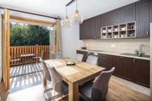 Una cocina y un comedor con mesa y sillas de madera. en Apartmán SOSNA, en Dolný Kubín