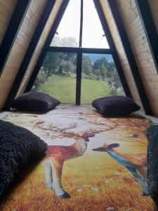 a bed in a room with a large window at Cabañas el condor del Ruíz in Murillo