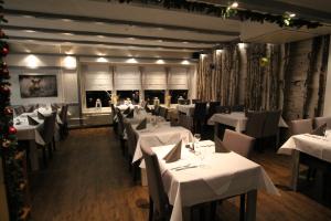 a restaurant with white tables and chairs and christmas decorations at Hotel Restaurant Jägerhof in Braunschweig