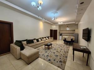 a living room with a couch and a table at غسق الليل 2 للشقق المخدومة in Al Qarāḩīn
