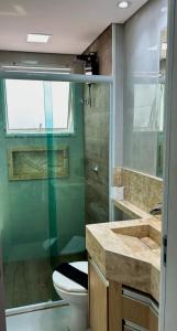 a bathroom with a toilet and a glass shower at Descubra seu novo espaço preferido em Americana-SP in Americana +21 photos