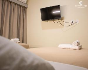 a hotel room with a bed with a tv on the wall at ALOJAMIENTO CENTENARIO in Corrientes