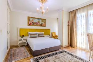 a bedroom with a white bed and a chandelier at Lemis Suite Istanbul in Istanbul