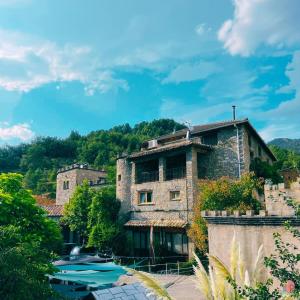 an old stone building with boats in front of it at Las Bodegas De Claveria in El Humo de Muro