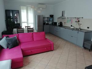 a living room with a pink couch and a kitchen at La Dodicesima Luna in Triuggio