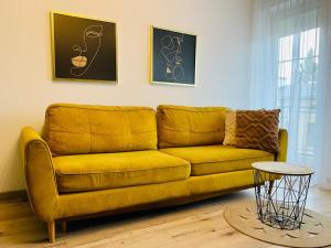 a yellow couch in a living room with a table at Blue Apartment close to Old Town in Bydgoszcz +58 photos