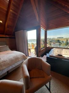 a bedroom with a bed and a tub and a chair at Salto Cabanas Village in São Francisco de Paula