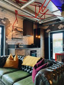 un soggiorno con divano in pelle di fronte a una cucina di The Funky Apartment a Groomsport