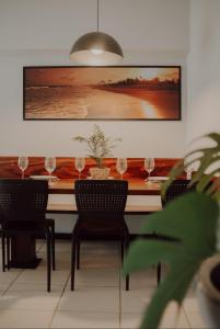 a dining room with a table with wine glasses at Apartamento de frente para a praia de Itaúna Saquarema in Saquarema