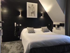 a bedroom with a large bed with a black wall at Hôtel La Mascotte & Restaurant Bellis Garden in La Baule