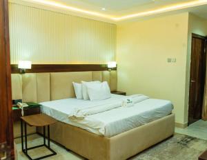 a bedroom with a large bed in a room at Wesley Hotels in Idunmwunivdiode