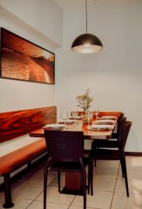 a dining room with a table and chairs with wine glasses at Apartamento de frente para a praia de Itaúna Saquarema in Saquarema +43 photos