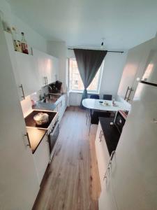 a kitchen with white cabinets and a wooden floor at Ankommen und wohlfühlen in Malmö in Västra Skrävlinge