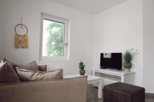 a living room with a couch and a tv at Palm Crest Curacao 150D in Willemstad